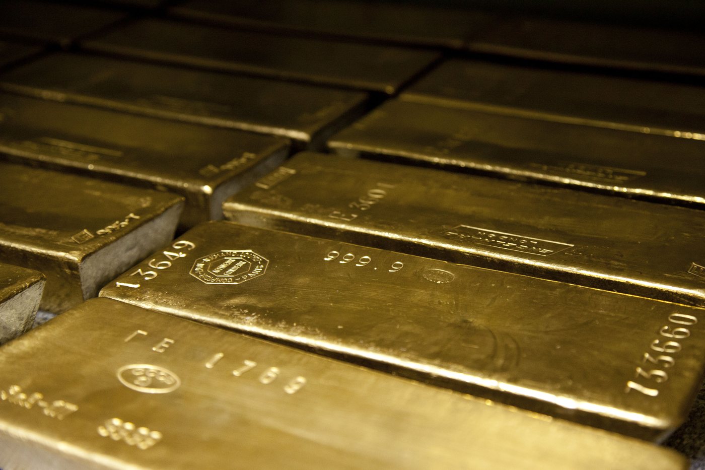 Four large gold bullion bars stacked together.