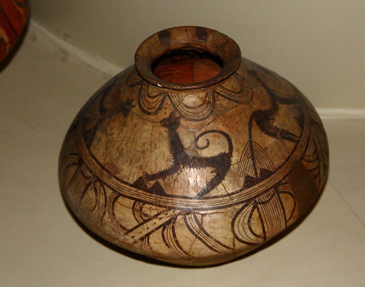 A Cucuteni-Trypillia painted vessel with dark spiral and animal motifs on a pale ground.