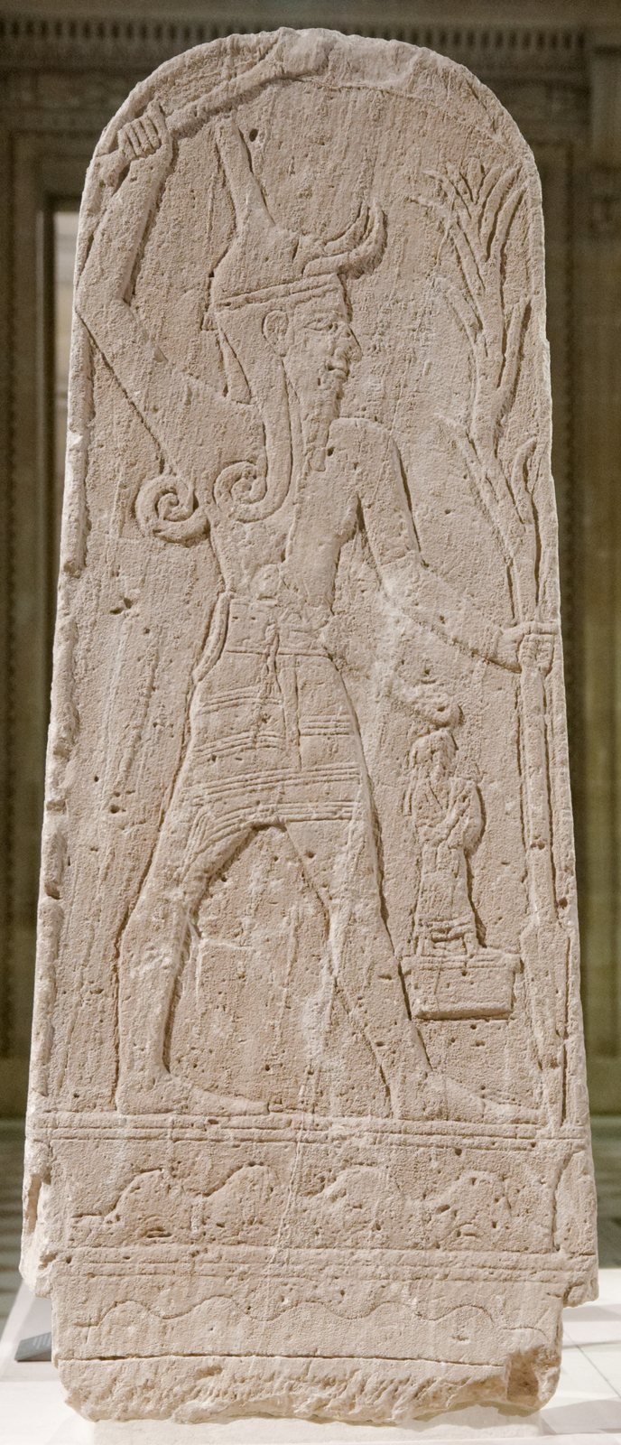 Stone stele of the god Baal holding a thunderbolt, from Ugarit.
