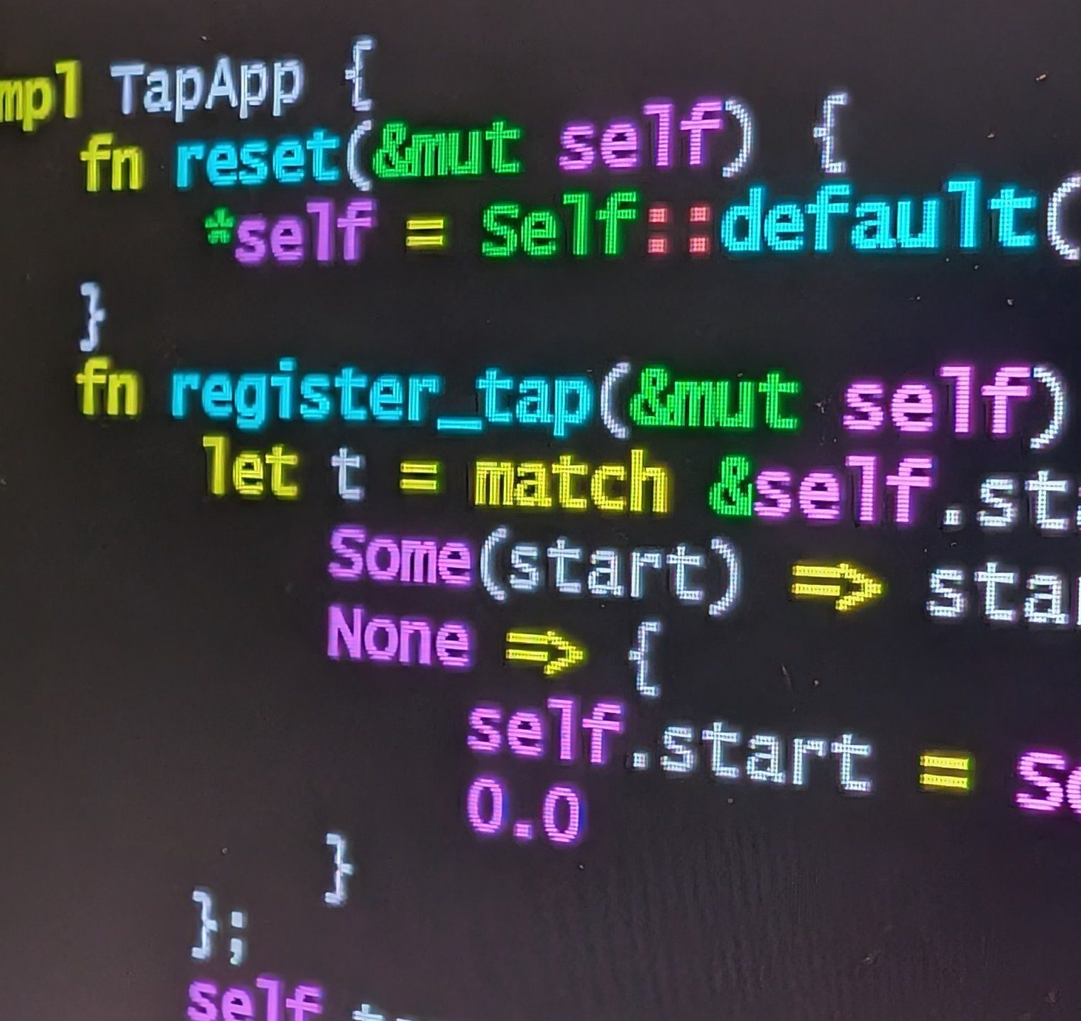 A close photograph of a laptop screen showing Rust code with a match on Some and None